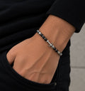 Bracelet homme perles noires et ancre en acier inoxydable porté au poignet
