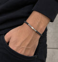 Bracelet homme perles noires mates et barre centrale en acier inoxydable porté au poignet
