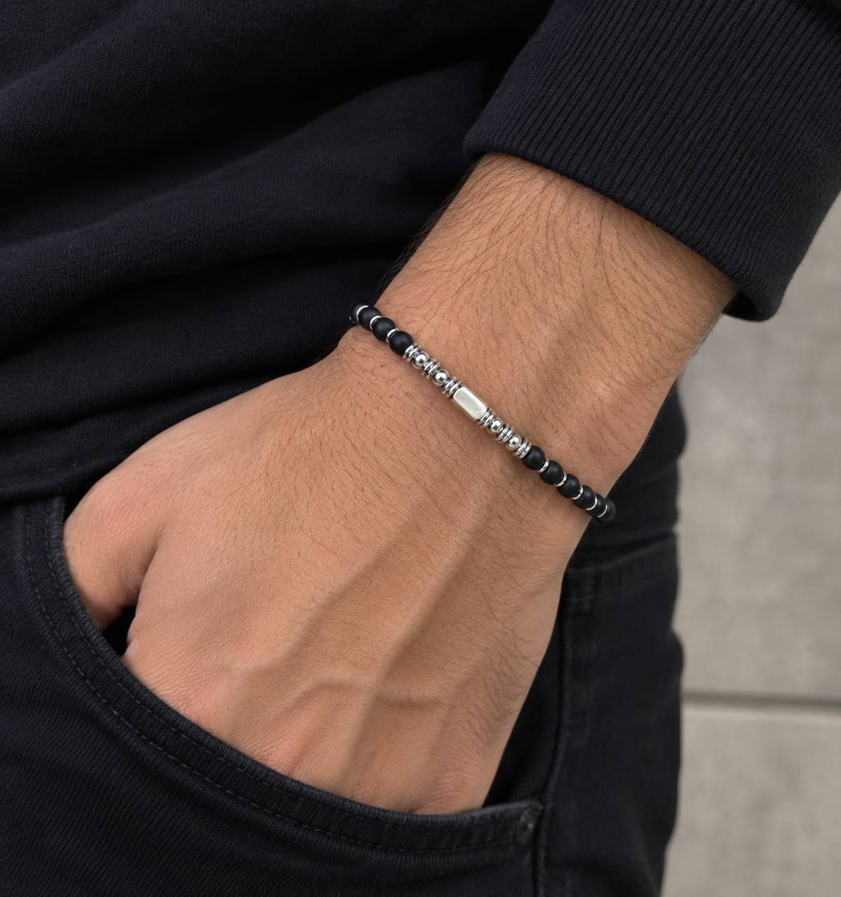 Bracelet homme perles noires mates et barre centrale en acier inoxydable porté au poignet